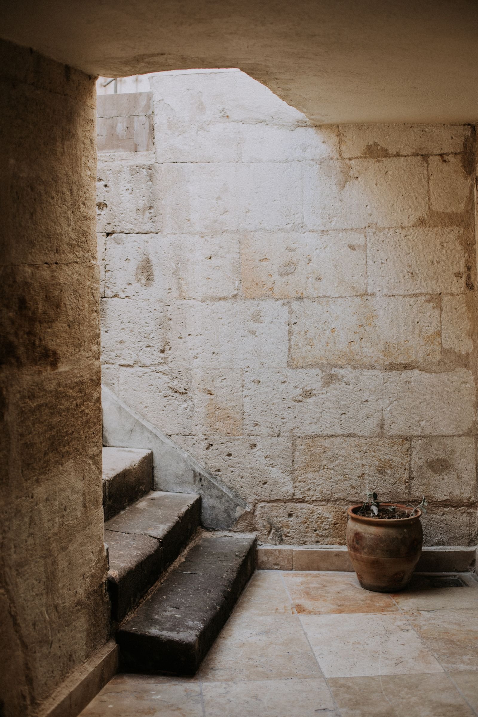 Cage d’escalier étroite d’un immeuble ancien, marches usées et rampe en bois