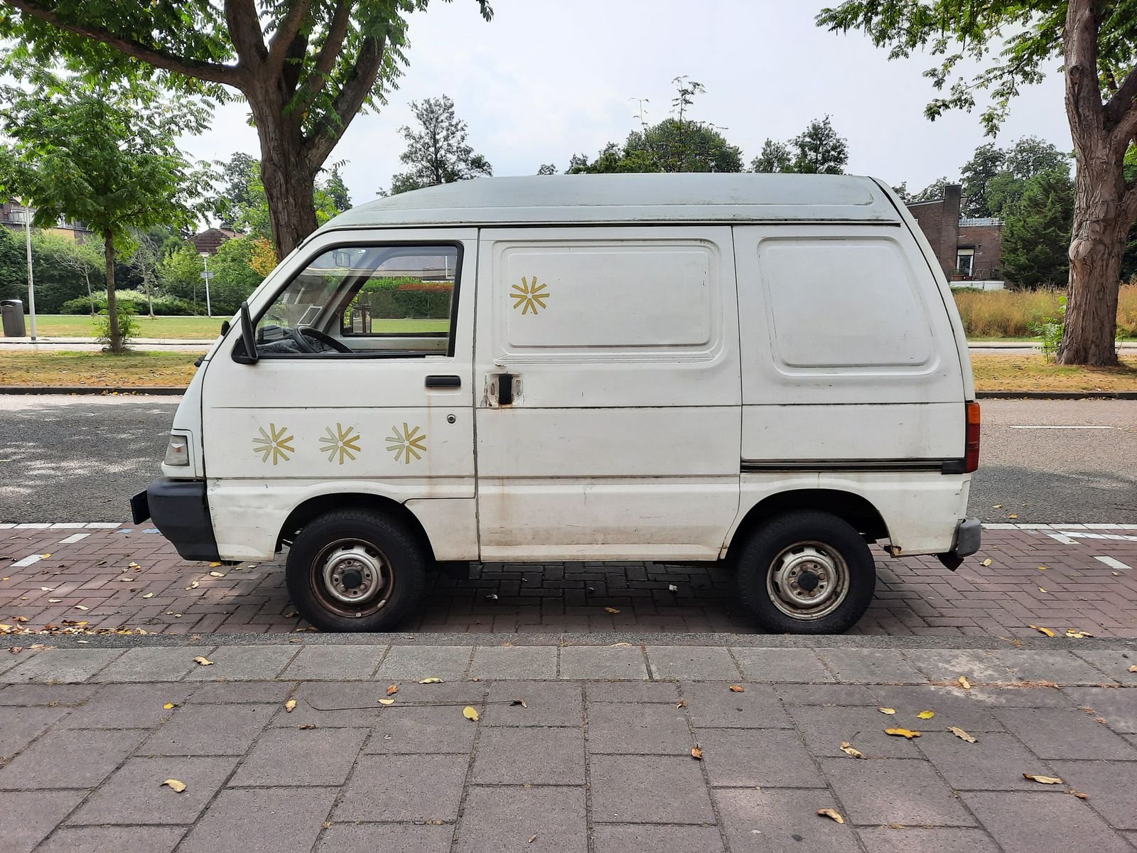 Utilitaire blanc sans logo ni lettrage, stationné le long d’un trottoir