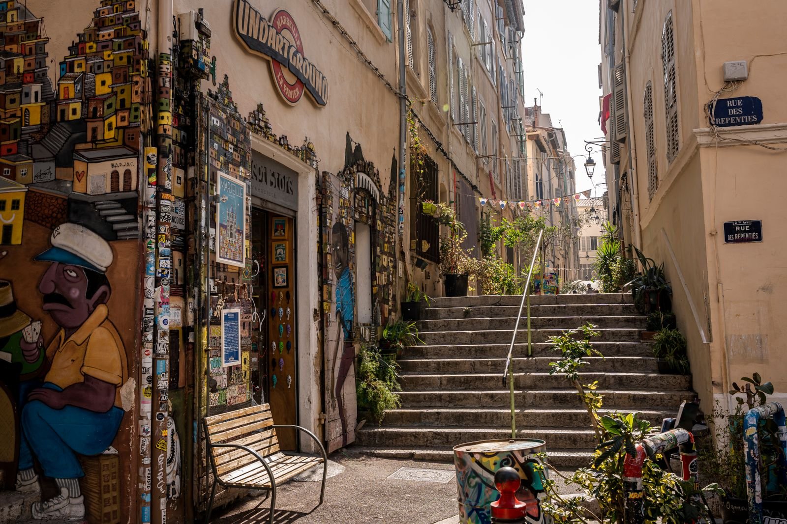 Escalier dans une ruelle marseillaise Ruelle en pente de Marseille avec escalier, façades peintes et plantes